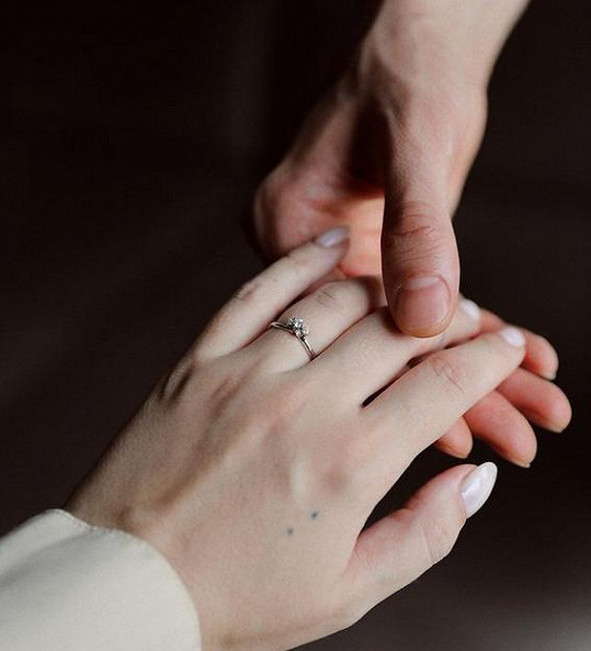 Partner jí navlékl krásný prsten s kamenem.