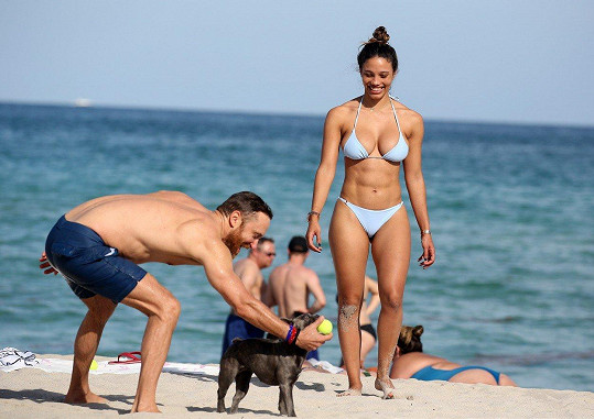 David si užíval slunečný den na pláži s krásnou přítelkyní a jejich psíkem. 