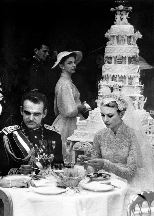 Grace Kelly s knížetem Rainierem III. při svatební hostině. V pozadí jejich dort s živými hrdličkami. 