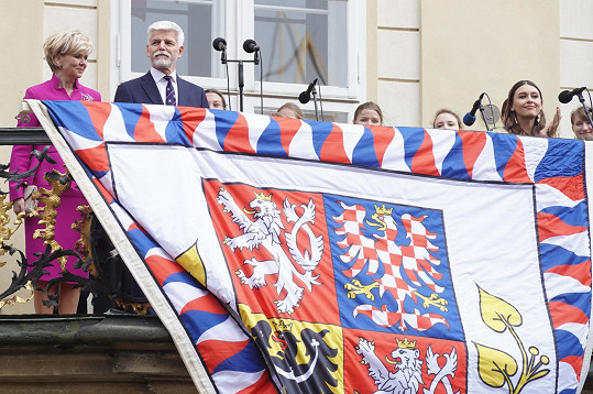 Prezident Petr Pavel s manželkou Evou zdraví z balkonu Pražského hradu.