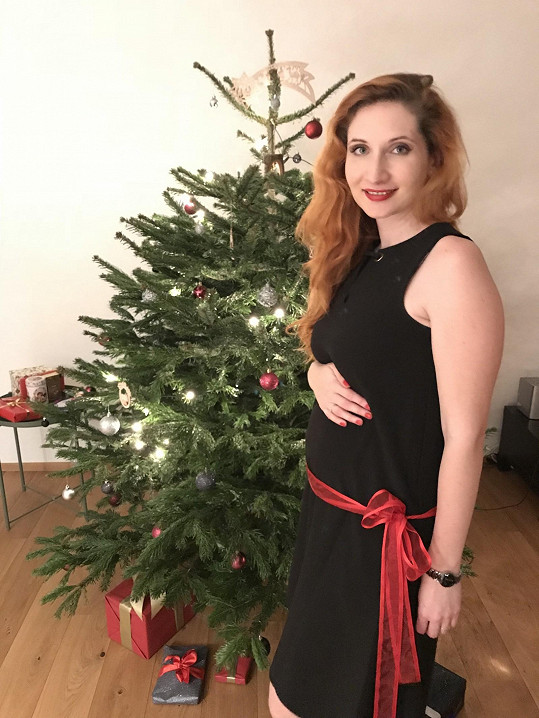 Těhotenství prozradila mašle na jejím břiše u vánočního stromku.
