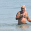 Harašící miliardář, který rád pracuje bez kalhot, se ukázal na pláži se svou mladou přítelkyní