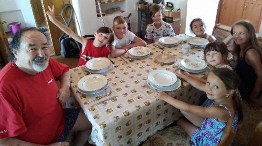 Petr Novotný je obklopený vnoučaty a jejich kamarády. 