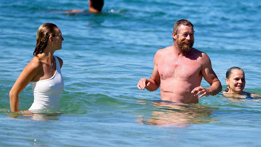 Seriálový Mentalista Simon Baker na pláži Bondi s neznámou kráskou v bílých plavkách 